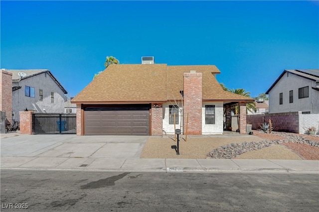 view of front facade with brick siding, fence, concrete driveway, a chimney, and an attached garage