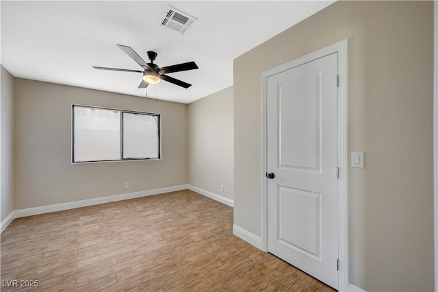 unfurnished room featuring light wood-type flooring, visible vents, baseboards, and ceiling fan