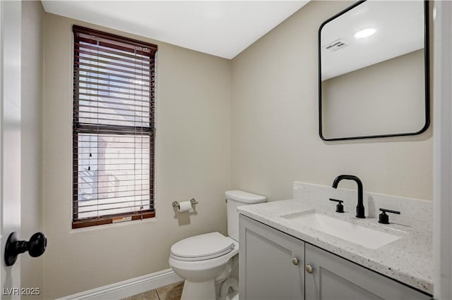 bathroom featuring vanity, toilet, a healthy amount of sunlight, and visible vents