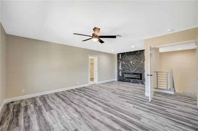 unfurnished living room with visible vents, a ceiling fan, wood finished floors, recessed lighting, and baseboards