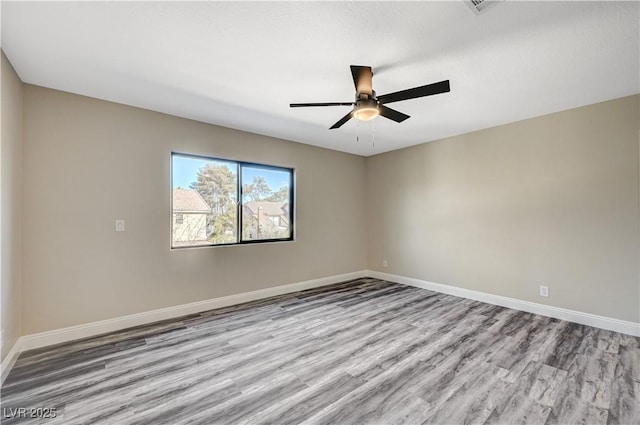 unfurnished room featuring wood finished floors, baseboards, and ceiling fan