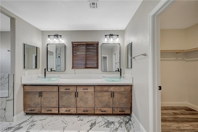 full bathroom with a sink, visible vents, a spacious closet, and double vanity