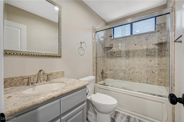 bathroom featuring wood finished floors, toilet, vanity, and bath / shower combo with glass door