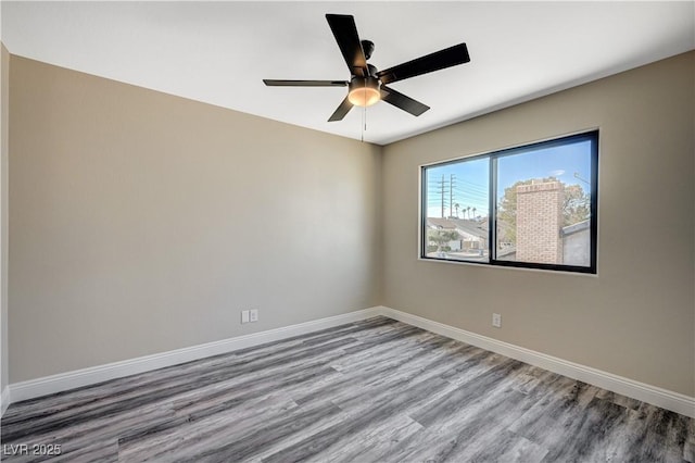 empty room featuring baseboards, wood finished floors, and a ceiling fan