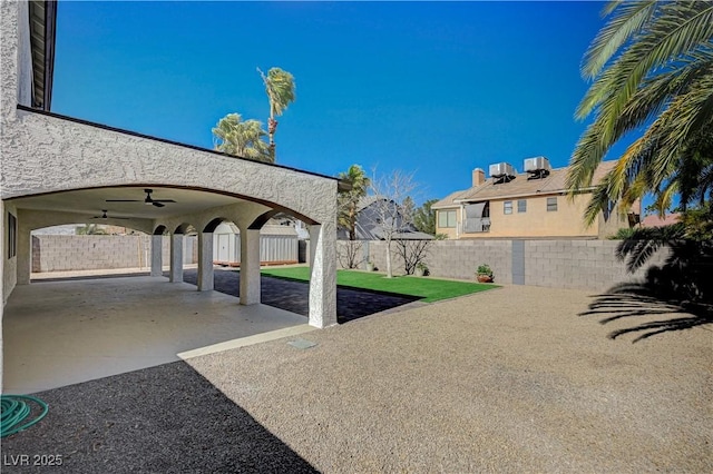 view of yard with a fenced backyard, a patio, and ceiling fan