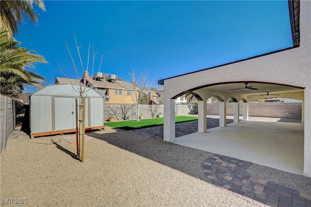 view of patio / terrace featuring an outbuilding, a fenced backyard, a storage shed, and ceiling fan