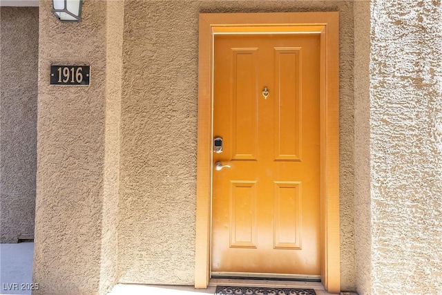 view of exterior entry with stucco siding