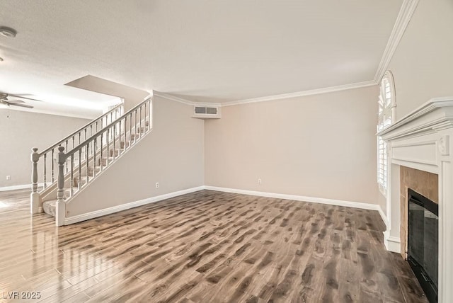 unfurnished living room featuring visible vents, wood finished floors, stairway, crown molding, and a tile fireplace