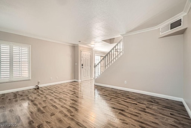 empty room with stairway, visible vents, wood finished floors, and crown molding