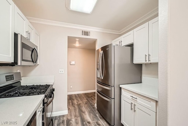 kitchen with white cabinetry, light countertops, appliances with stainless steel finishes, and ornamental molding