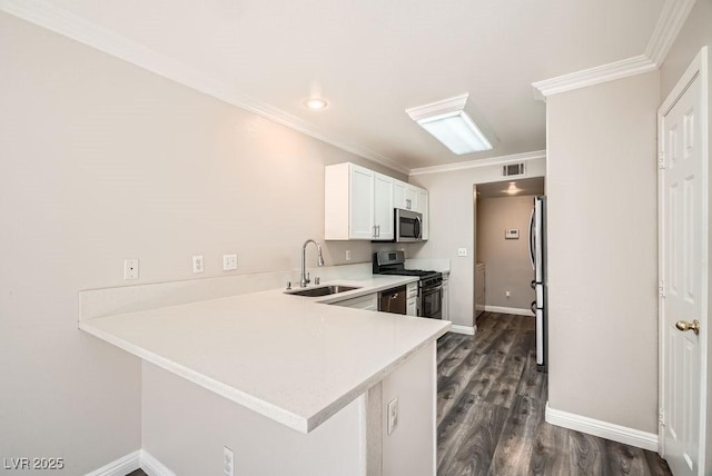 kitchen featuring visible vents, light countertops, ornamental molding, stainless steel appliances, and a sink