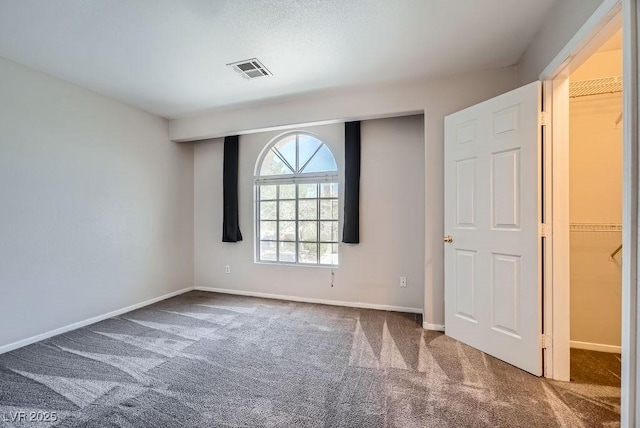 spare room with visible vents, carpet flooring, and baseboards