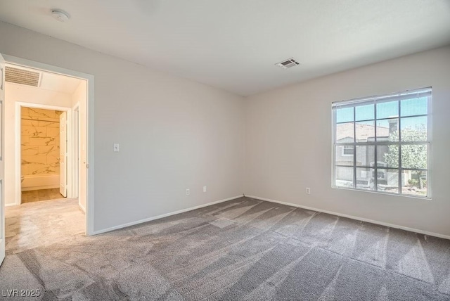 spare room featuring visible vents, carpet floors, and baseboards