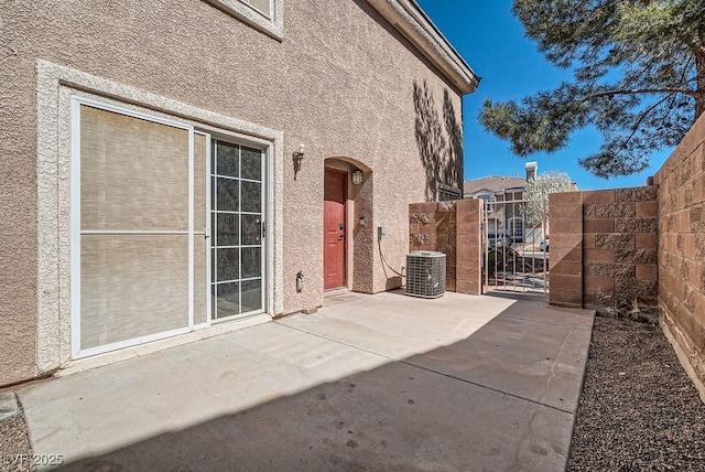 view of patio with a gate, cooling unit, and fence