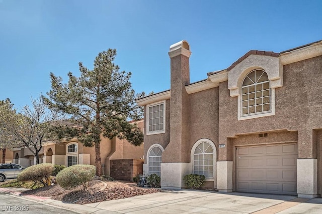 view of front of property featuring stucco siding, driveway, and a garage