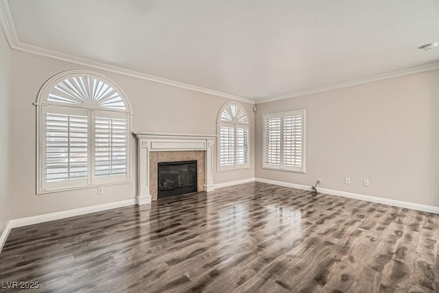 unfurnished living room featuring dark wood-style floors, a tiled fireplace, crown molding, and baseboards