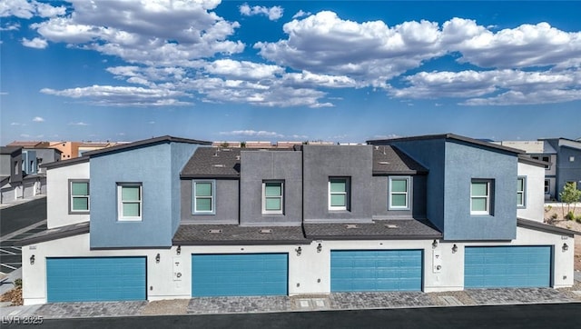 multi unit property featuring stucco siding, a residential view, and a garage