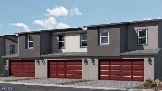 view of property featuring an attached garage and stucco siding