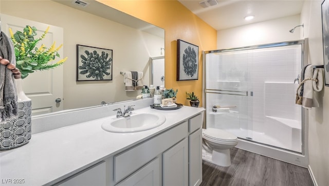 full bath featuring visible vents, toilet, a stall shower, wood finished floors, and vanity