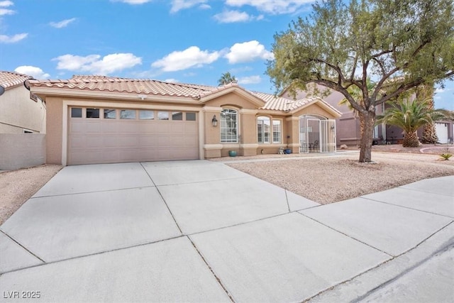 mediterranean / spanish house featuring stucco siding, driveway, fence, an attached garage, and a tiled roof