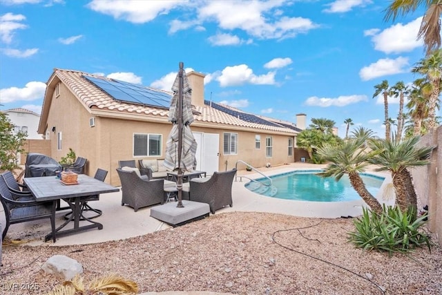 rear view of property with a patio area, stucco siding, an outdoor hangout area, and a fenced in pool