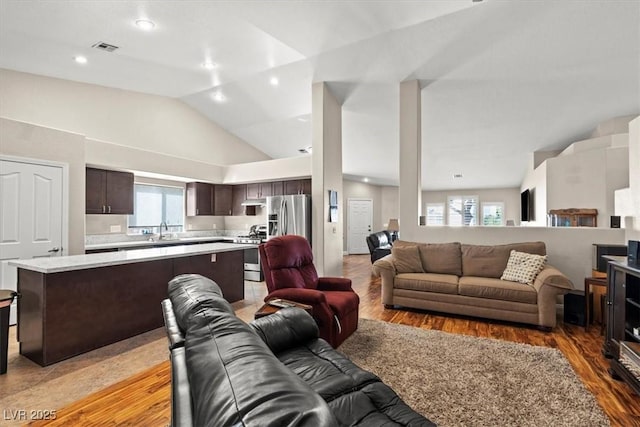 living room with visible vents, plenty of natural light, and light wood-style flooring