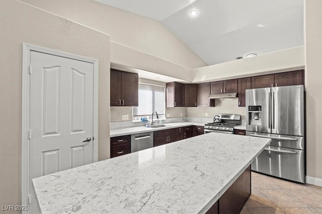 kitchen featuring dark brown cabinets, under cabinet range hood, vaulted ceiling, appliances with stainless steel finishes, and a sink