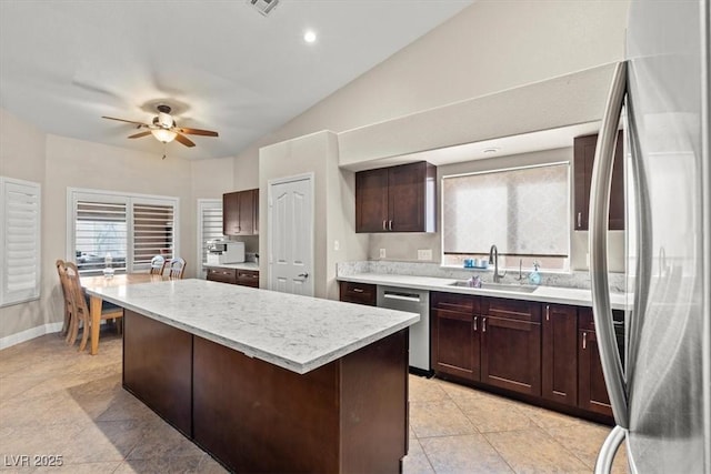 kitchen featuring a sink, a kitchen island, stainless steel appliances, dark brown cabinetry, and lofted ceiling