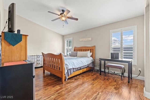 bedroom with baseboards, multiple windows, lofted ceiling, and light wood finished floors