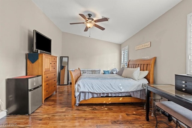 bedroom featuring a ceiling fan, freestanding refrigerator, lofted ceiling, and wood finished floors