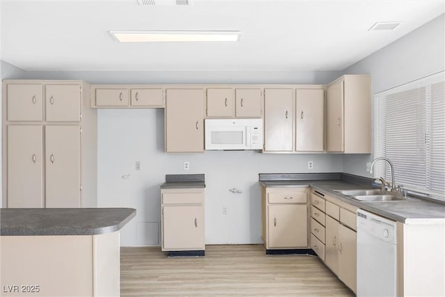 kitchen featuring a sink, white appliances, cream cabinetry, and light wood-style flooring