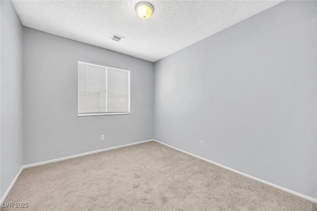 carpeted empty room featuring visible vents, baseboards, and a textured ceiling