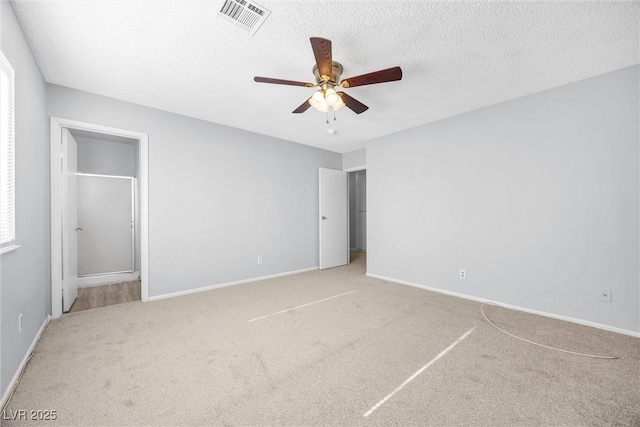 unfurnished bedroom featuring visible vents, baseboards, a textured ceiling, and carpet flooring