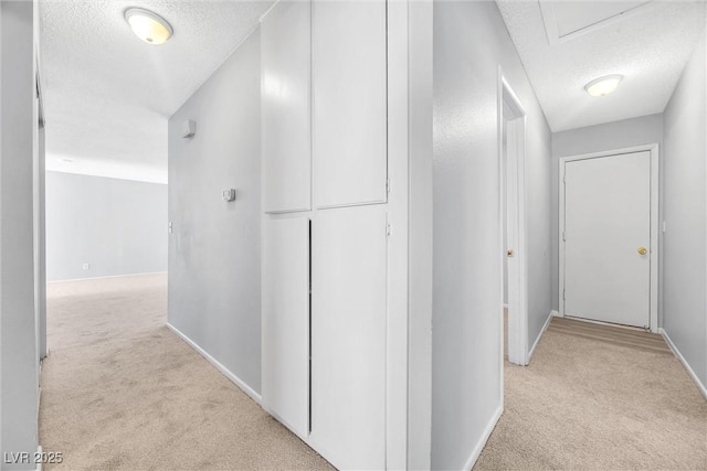 corridor with baseboards, a textured ceiling, and carpet