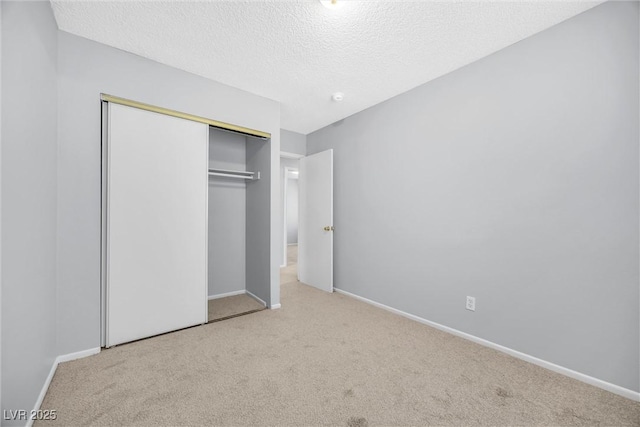 unfurnished bedroom with a closet, baseboards, carpet, and a textured ceiling