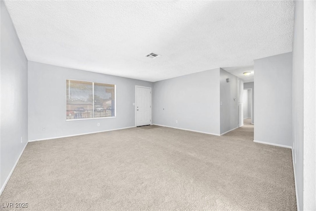 unfurnished room featuring visible vents, carpet floors, a textured ceiling, and baseboards