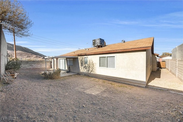 rear view of house featuring cooling unit, a patio, a fenced backyard, and stucco siding