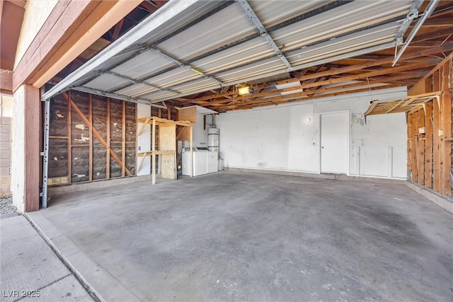 garage featuring strapped water heater, a garage door opener, and washer and clothes dryer