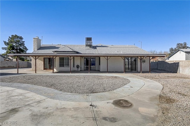 back of property with a patio, fence, and a chimney