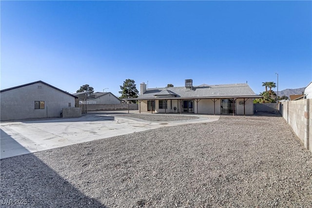 back of property featuring a patio area, solar panels, and a fenced backyard