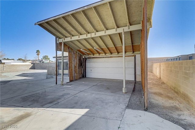 garage featuring a carport and fence