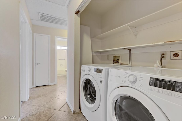 clothes washing area with light tile patterned floors, baseboards, visible vents, laundry area, and washer and clothes dryer