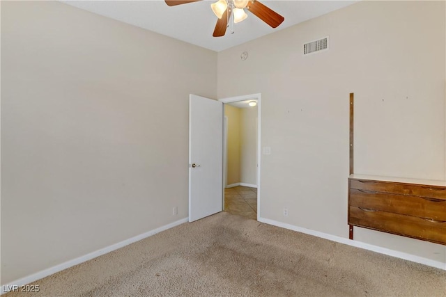 carpeted empty room featuring a ceiling fan, baseboards, and visible vents