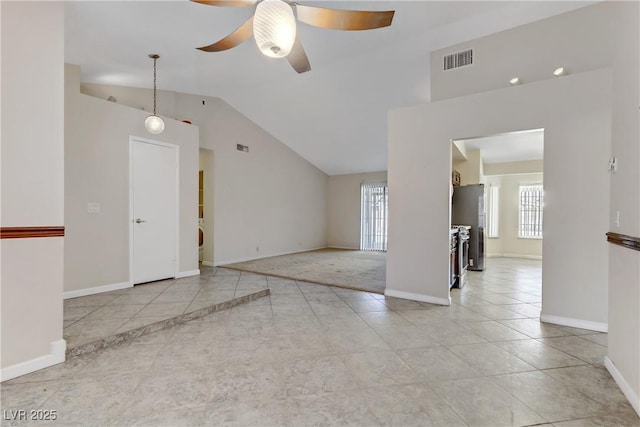 empty room featuring visible vents, ceiling fan, baseboards, vaulted ceiling, and light tile patterned flooring