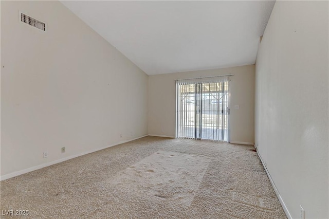 unfurnished room with vaulted ceiling, light colored carpet, visible vents, and baseboards