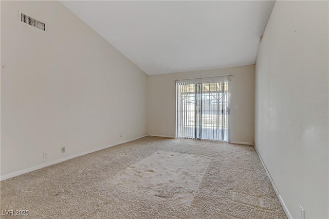 carpeted empty room featuring visible vents, baseboards, and vaulted ceiling