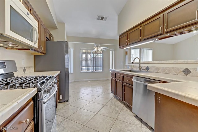 kitchen featuring a sink, tile counters, visible vents, and stainless steel appliances