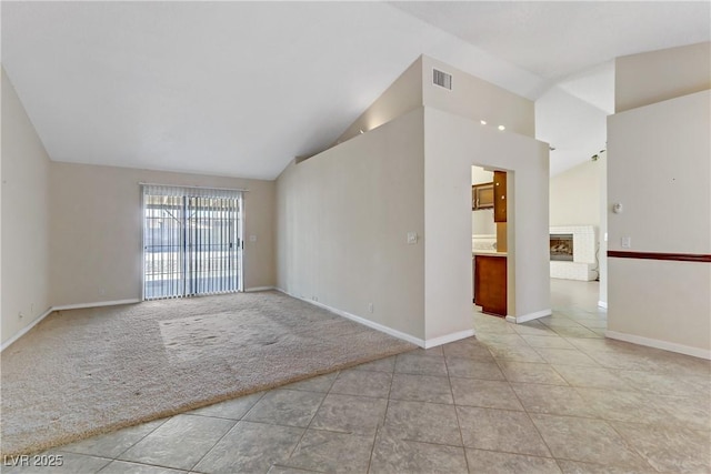 empty room featuring visible vents, light carpet, high vaulted ceiling, baseboards, and a brick fireplace