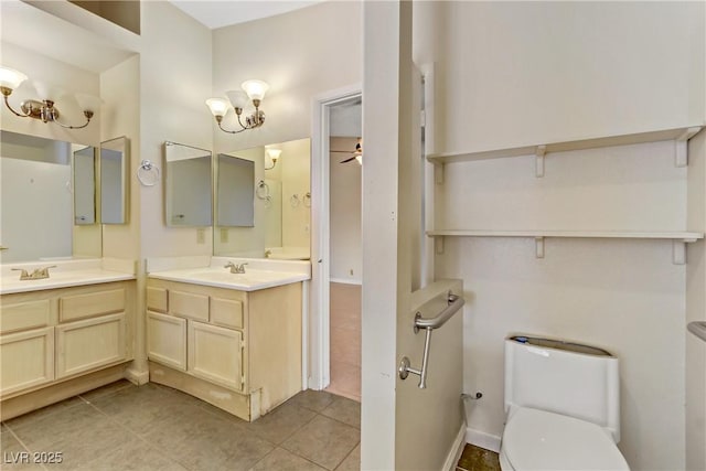 bathroom with tile patterned floors, toilet, vanity, and a ceiling fan