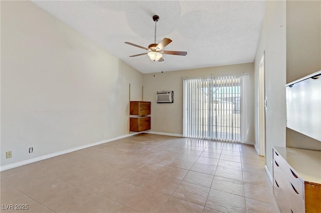 empty room with baseboards, ceiling fan, light tile patterned floors, a textured ceiling, and a wall mounted AC